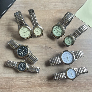 Close-up of elastic steel watches with black and white dials on wooden background