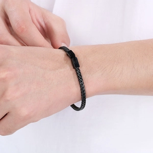 Detailansicht eines schwarzen Edelstahl-Drachenknochen-Armbands am Handgelenk eines Mannes