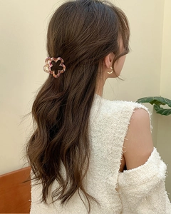 Detail of amber floral flower hair claw clip used in an elegant half-up hairstyle