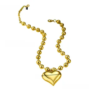 Macro shot of large polished gold heart pendant and round bead chain with dimensions