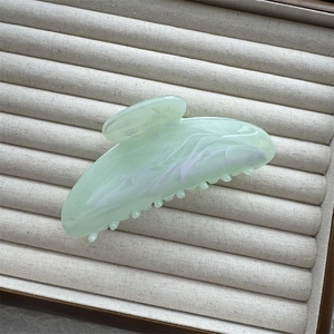 Detail of light green marble ink texture on large acetate shark hair claw clip