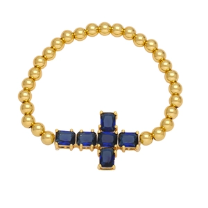 Gold beaded bracelet featuring a minimalist cross pendant set with blue zircons