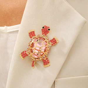 Broche tortue vintage avec pierre rose et cristaux rouges sur revers de costume