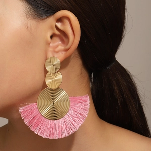 Details von böhmischen Ohrringen mit rosa Quasten und goldenen Metallscheiben am Model