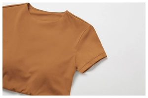 Détail d'un crop top de yoga gingembre montrant des coutures fines et un tissu sport élastique