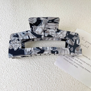 Large marble pattern acetate hair claw clip for elegant women hairstyles on beige background