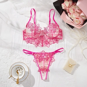 Flat lay of pink French embroidery lace bra and thong set with elegant floral details
