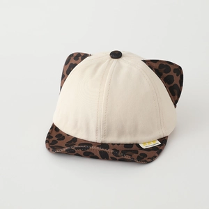 Dettaglio del cappello beige per neonati con orecchie leopardate e tesa morbida