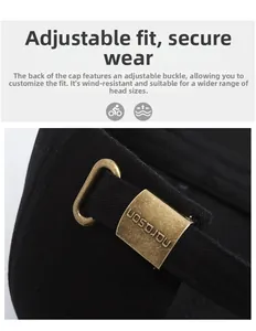 Close-up of adjustable bronze metal buckle and black strap on a cotton baseball cap