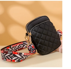 Detail of black quilted nylon crossbody bag with geometric pattern wide shoulder strap