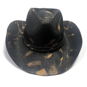 Detailed texture of black woven cowboy hat featuring gold splatter pattern on wide brim