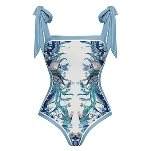 Detail of blue floral swimsuit featuring knotted bow shoulder straps and ethnic pattern