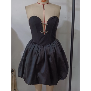 Detail of black strapless evening dress with rhinestone bow accents and bubble hemline