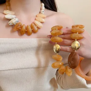 Irregular amber acrylic necklace and bracelet set with golden beads for women