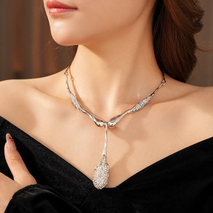 Détail du collier avec pendentif goutte d'argent et strass porté sur le cou d'un modèle