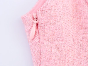 Macro view of a pink tweed dress showing the high-quality invisible zipper detail