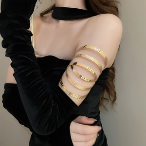 Close-up of golden multi-layer arm cuff with irregular hammered texture on model's arm