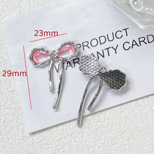 Détail d'un pendentif nœud rose 23mm x 29mm avec dos en métal argenté pour bijoux DIY