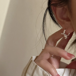 Elegant s925 sterling silver knot hoop earrings with textured finish on model