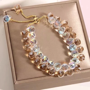 Macro shot of colorful iridescent crystal beads on a gold adjustable chain bracelet