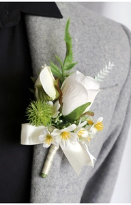 Detail of white rose boutonniere with green berries on a gray suit lapel for weddings