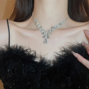 Close-up of sparkling silver Y-shaped necklace with teardrop crystal on female model