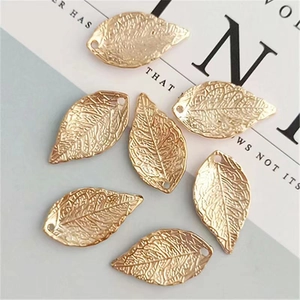 Detailed view of 7 gold leaf metal charms with fine vein textures for DIY jewelry making