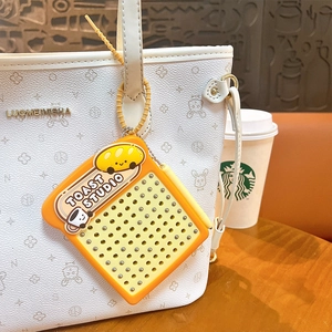 Square magnetic toast fidget keychain with 90 metal beads hanging on a white tote bag.
