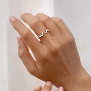 Detailed view of silver open ring with leaf-shaped sparkling crystals on a model hand