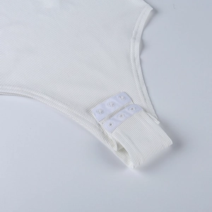 Close-up of white ribbed bodysuit showing fabric texture and bottom snap closure buttons