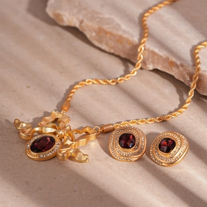 Vintage gold necklace and earrings set with red gemstones and sparkling rhinestones