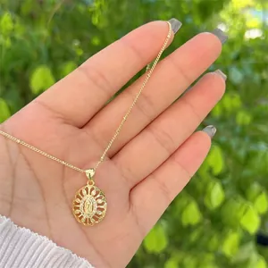 Detailed view of 18K gold plated Virgin Mary pendant with pave zircons held by hand