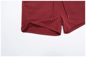 Detailed macro view of burgundy sports shorts featuring adjustable drawstring and loopback knit