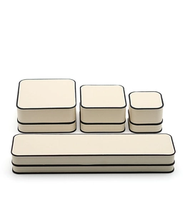Macro detail of luxury beige jewelry boxes with black trim in various display sizes
