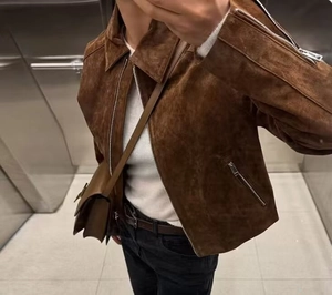 Detail der braunen Wildleder-Bikerjacke mit silbernem Metallreißverschluss und Reverskragen