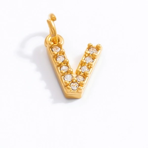 Macro shot of gold-plated letter V pendant with sparkling cubic zirconia stones