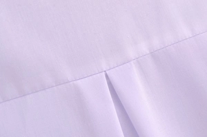 Detail of light purple blouse showing stitching and pleat on woven cotton fabric