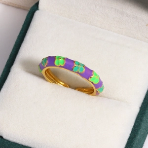 Detail of gold floral ring with purple and green enamel in a velvet jewelry box