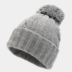 Detail of grey cable knit beanie with large pom-pom and thick cuff for winter warmth