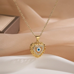 Gold-plated heart pendant necklace with evil eye zircon inlay on champagne satin background