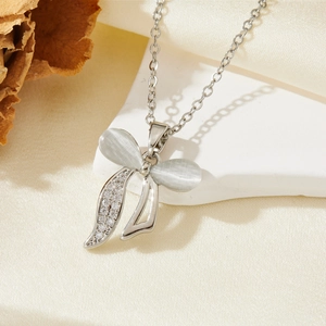 Détail du collier nœud argenté avec pierre œil de chat blanche et cristaux scintillants