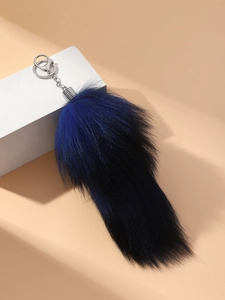 Detailed view of fluffy navy blue faux fur tail keychain with silver metal clip