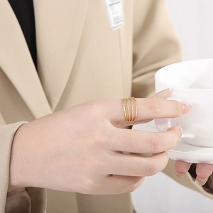 Detail of a four-layer gold-plated leaf ring with bead texture on a model's hand