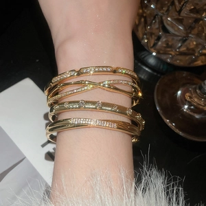 Close-up of 18k gold plated bracelets set with sparkling cubic zirconia on a model wrist