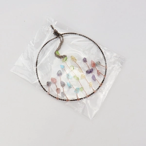 Detail of tree of life suncatcher with colorful crushed crystals and copper wire wrapping