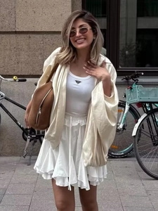 Completo street style da donna con gonna a balze bianca e cardigan beige in stile urbano