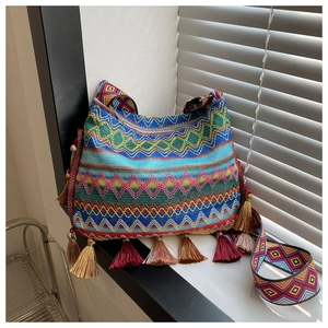 Close-up of ethnic woven crossbody bag with colorful patterns and tassel details