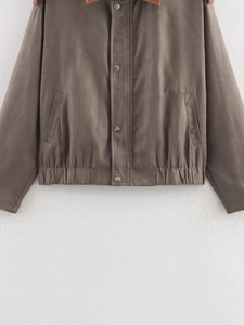 Detail of a brown faux suede jacket with silver metal snaps and elastic hem