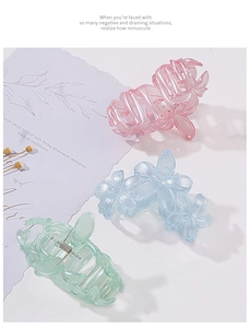 Detail of pink, blue, and green floral hair claws on a clean white background