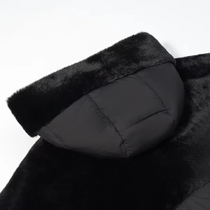 Detailed close-up of a warm black jacket hood featuring a thick faux fur trim and lining
